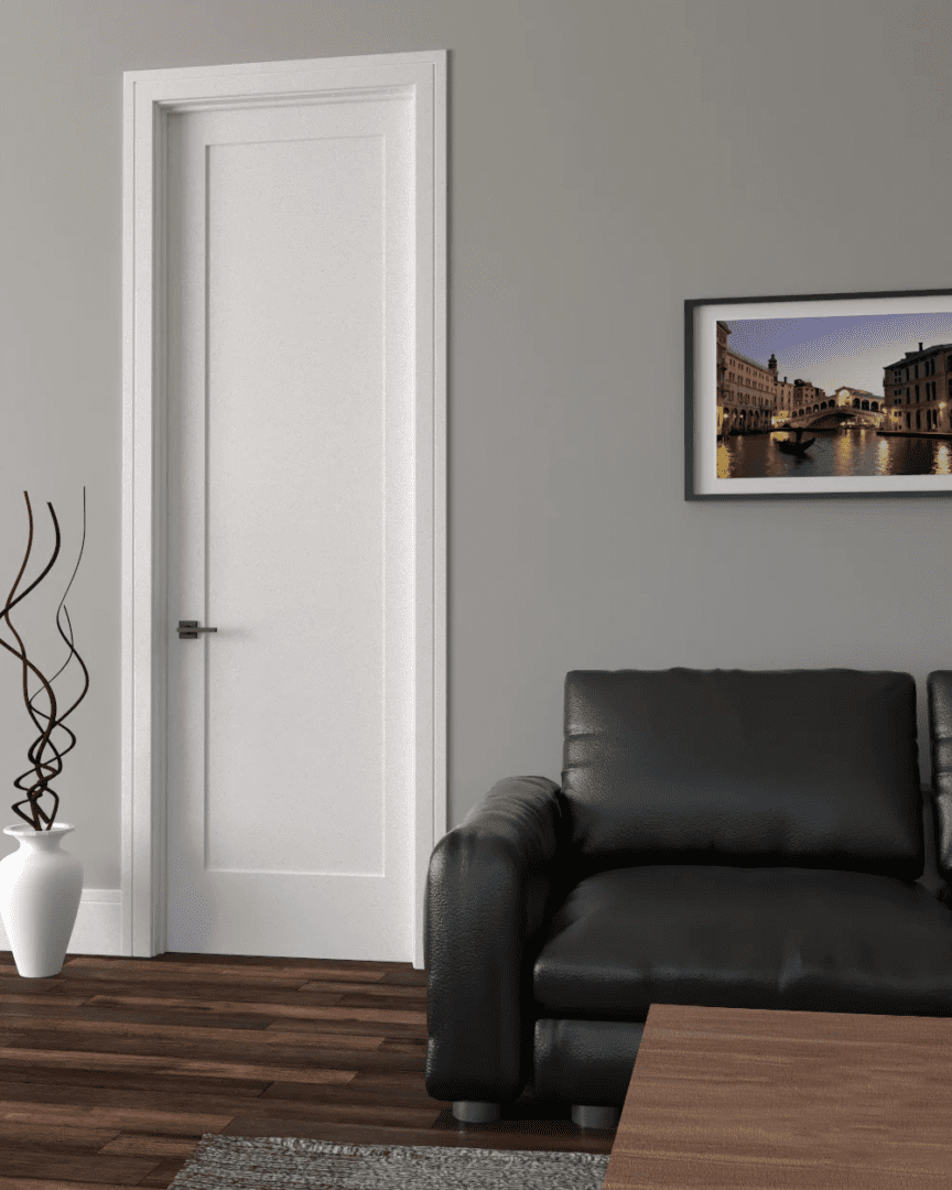 A modern living room featuring a black leather sofa, a white vase with decorative twigs, a rug, and a framed picture of a venice canal on the wall.